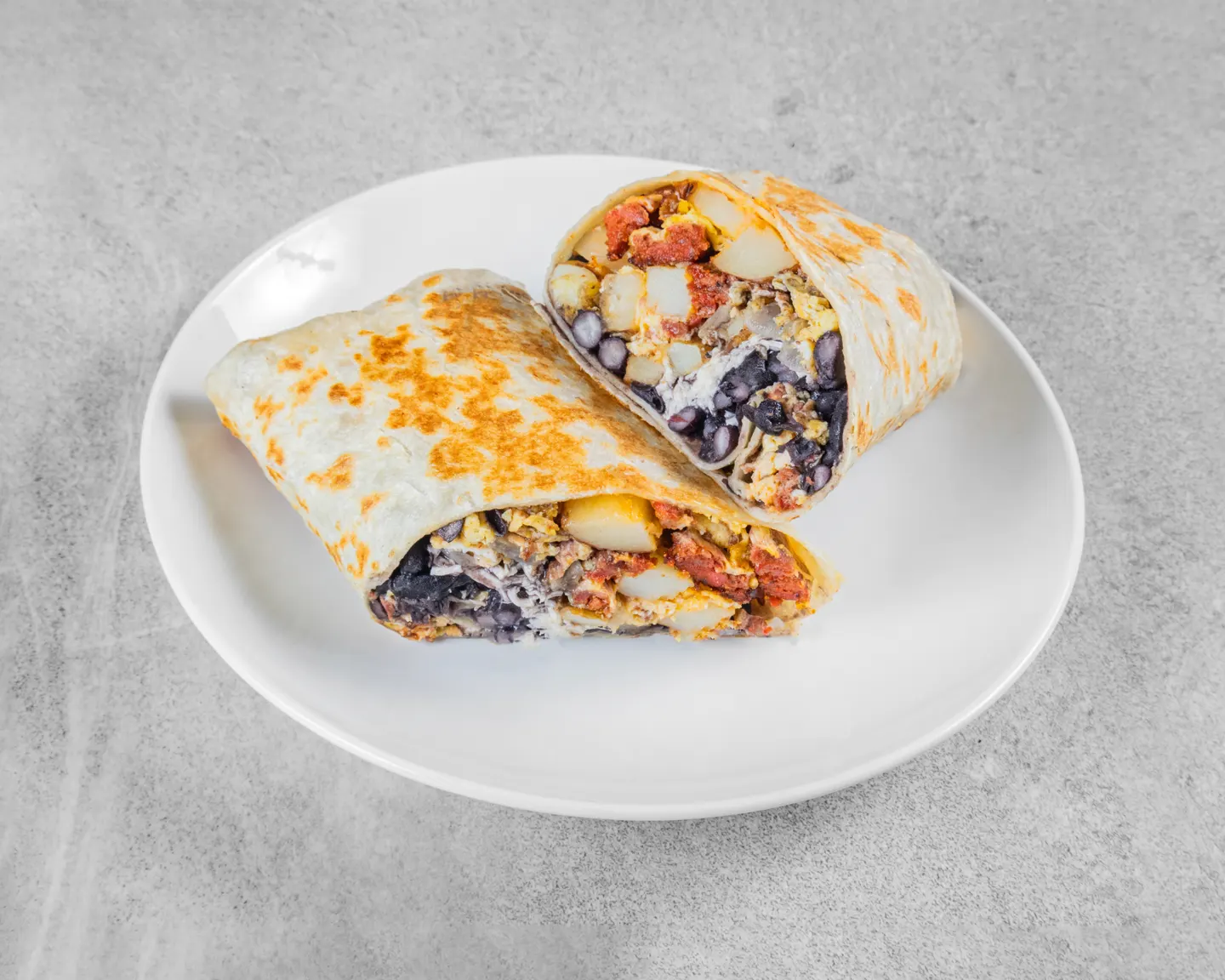 Burrito de desayuno abierto con huevos, papas, frijoles y chorizo